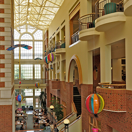 ZSR Library interior photo shows colorful hangings and students studying below