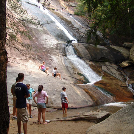 Kids enjoy a waterfall at Stone Mountain State Park